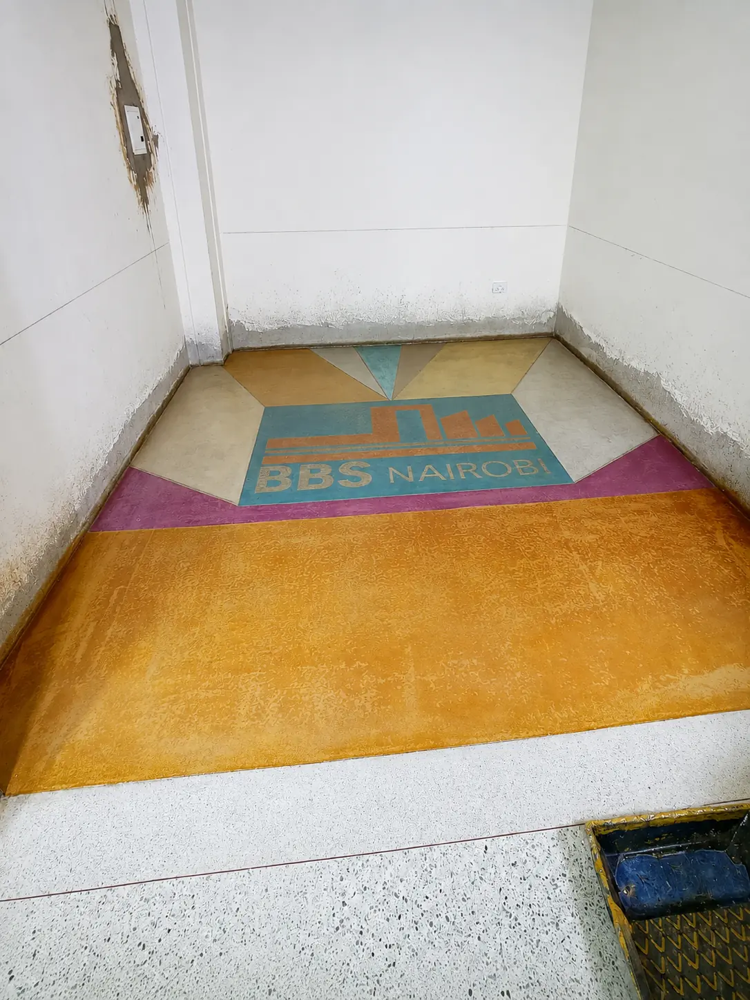 Orange and blue custom terrazzo identity feature integrated into a floor