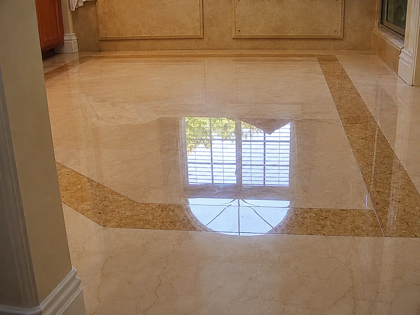 Polished beige marble floor with a crisp reflection in a residential interior