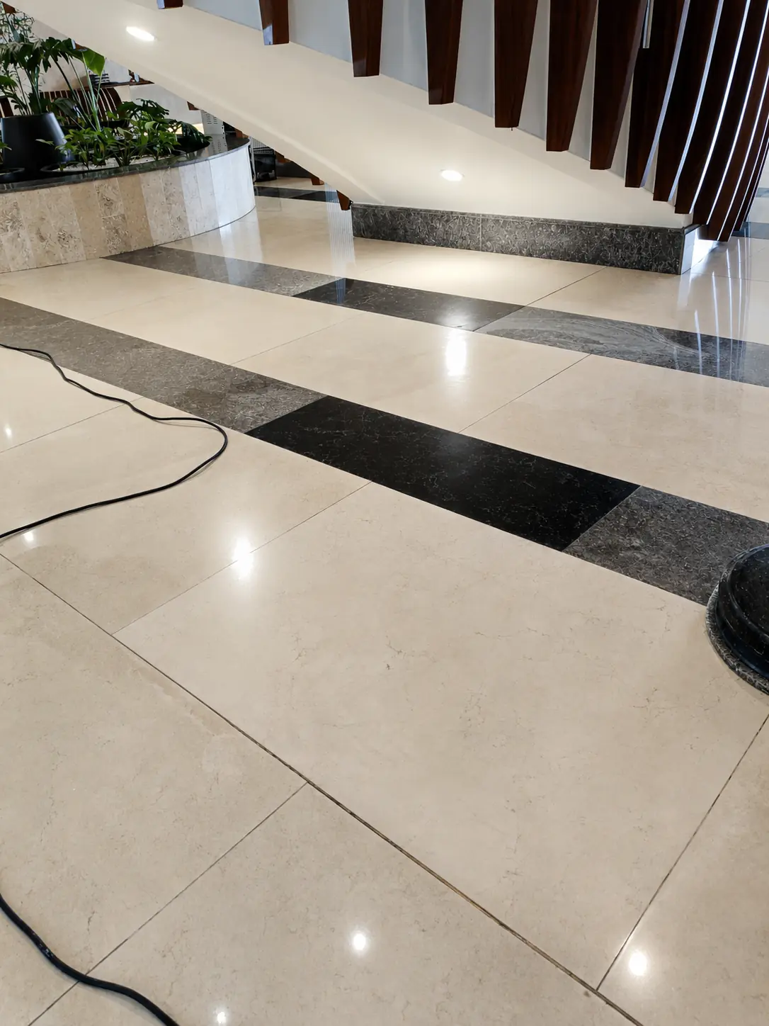 Polished cream marble floor beneath a feature staircase in a residential interior