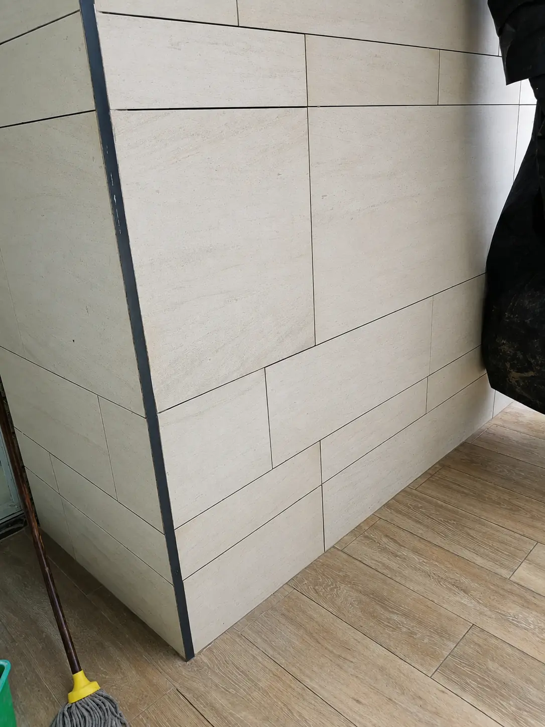 Large-format cream natural stone wall meeting an interior corner