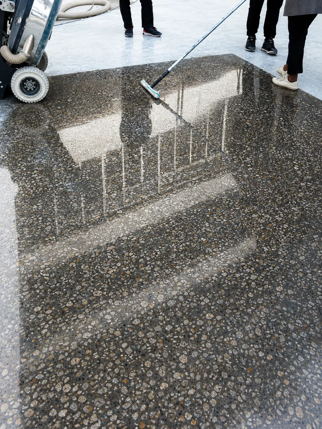 Deep aggregate polished concrete floor beside active finishing equipment