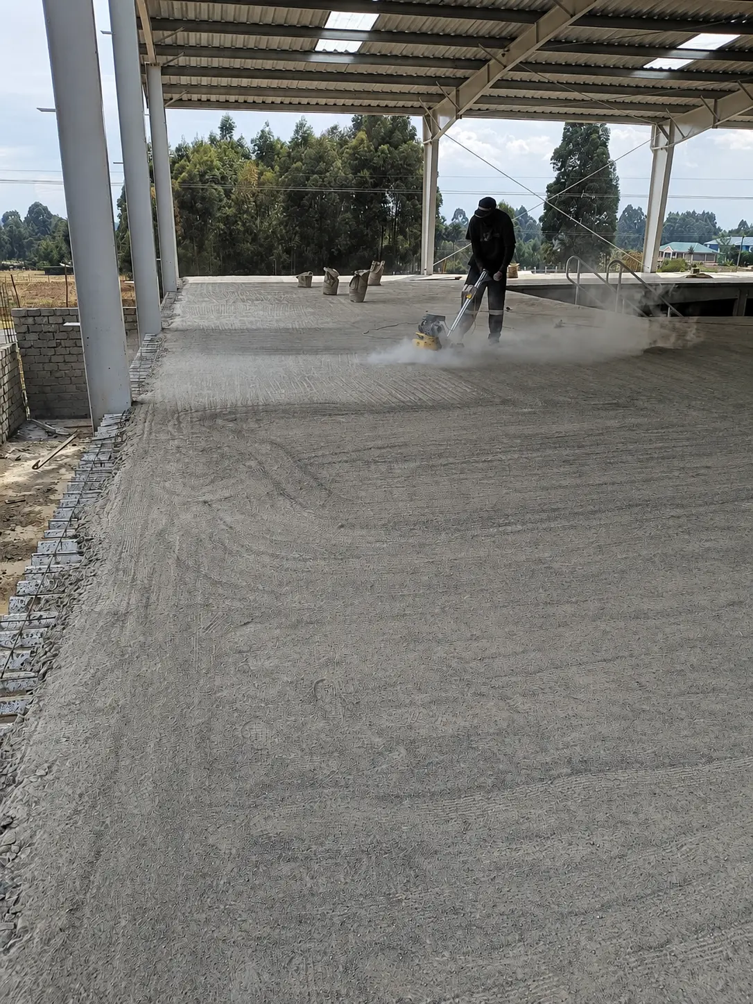 Technician carrying out early-stage preparation across a large exterior slab