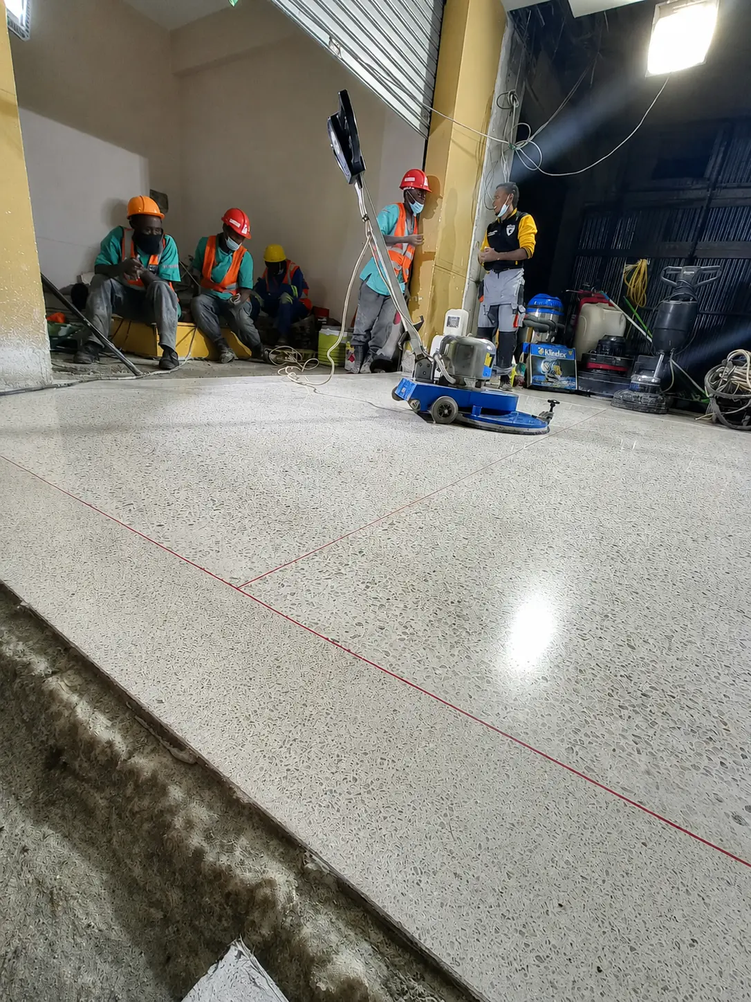 Sakafu site team coordinating floor-machine work during refinement