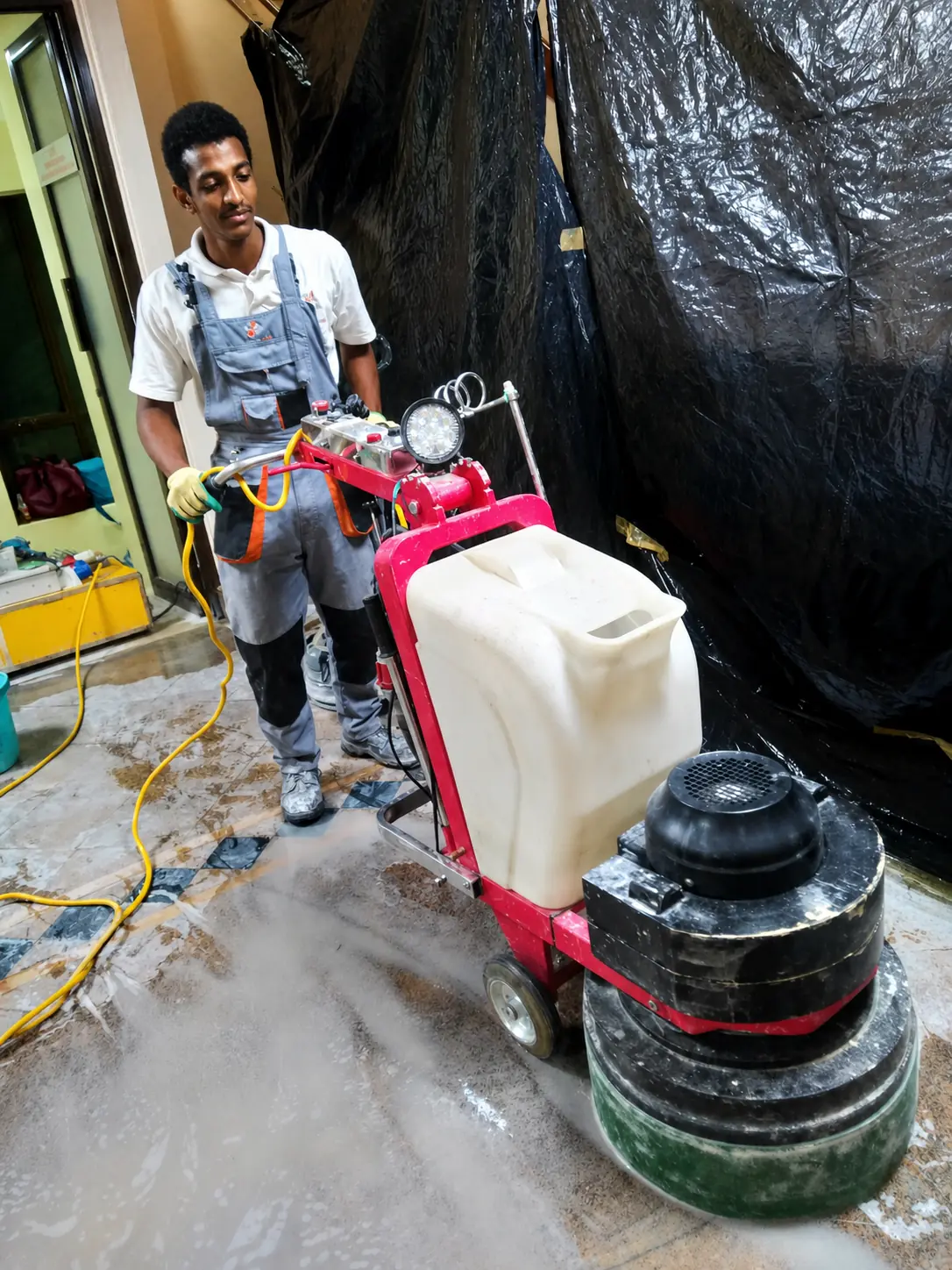 Sakafu technician operating a planetary floor polishing machine